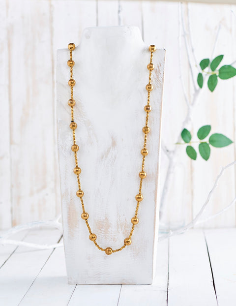Handwoven long Dhokra necklace made of different sized brass beads